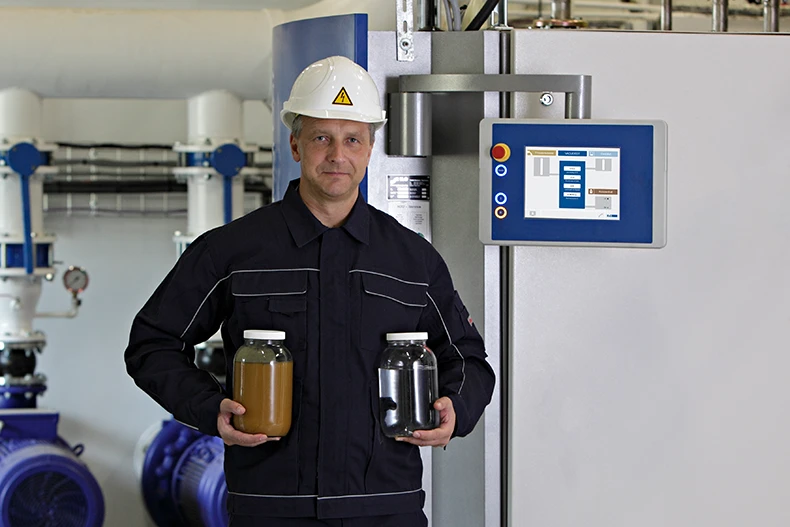 H2O employee shows a container of wastewater and a container of treated water