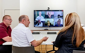 A group of H2O employees in front of a monitor during an online meeting