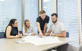 A group of H2O employees discussing a plan at a meeting table