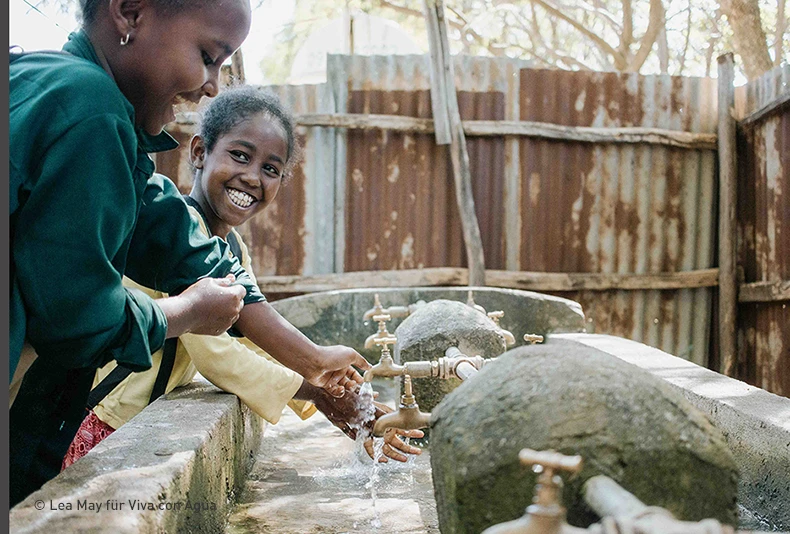 A photo of happy Ethiopian children at a water pump. Photo by Lea May. 