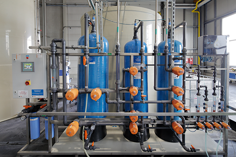 An ion exchanger consisting of several metal tanks and pipes in a production plant.