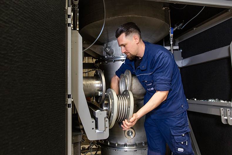 A technician from H2O GmbH works on setting up a vacuum distillation system.